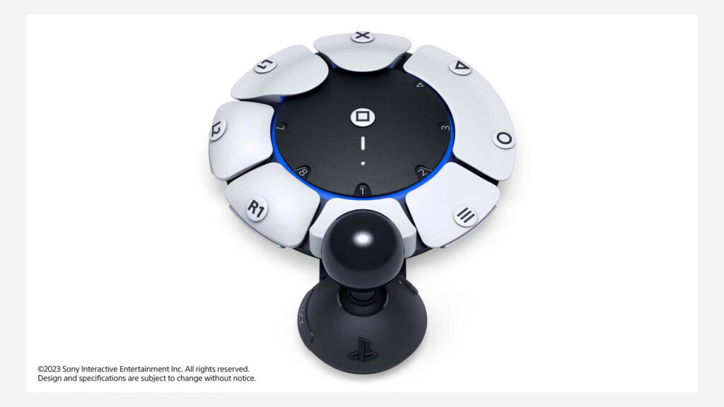 Circular controller surrounded by 8 buttons, rather like a clock face. The buttons appear to be removable and modular, each with a different label, such as "X" or "R1". Attached to the controller is a joystick.